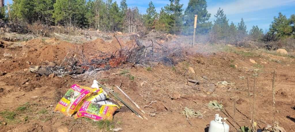 Burning brush to make bio-char for the dryland hugelkultur at stony oasis farms.